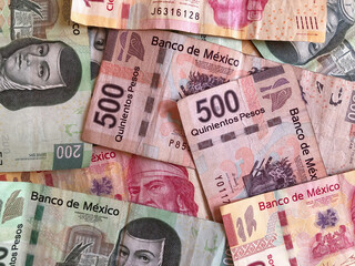 Mexican peso bills spread over a desk