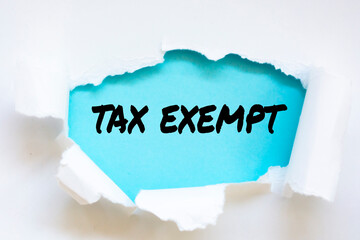 The word tax exempt appearing behind torn paper