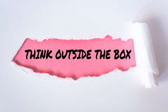 Phrase THINK OUTSIDE THE BOX appearing behind torn white paper. For background purpose.