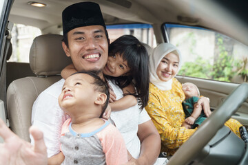 Muslim family travel by car during eid mubarak celebration. asian people going back to their hometown