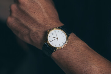 fashionable wearing stylish looking at luxury watch on hand check the time at workplace.concept for managing time organization working,punctuality,appointment