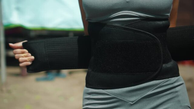 European sports girl stands on the beach in the belt for weight loss with sweat withdrawal for fitness occupation