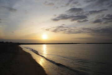 Fototapeta na wymiar 朝日が昇る須磨浦海浜公園の夜明け。雲と海がオレンジ色に染まる。