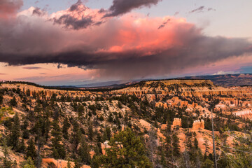 dramatic landscape photo of Bryce Canyon.gigantic  cumulonimbus desert storm cloud passing through the hoodoos of the Bryce Canyon National Park just right after sunset.
