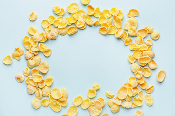 Frame made of cornflakes on color background
