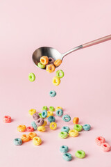 Spoon with tasty cereal rings on color background