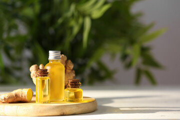 Bottles with ginger essential oil on table