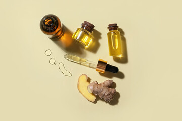 Bottles with ginger essential oil on color background