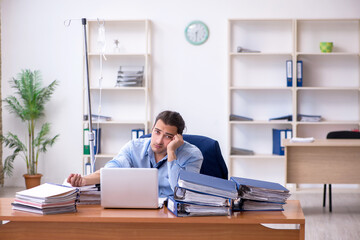 Young male employee suffering at workplace
