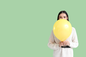 Beautiful young woman with balloon on color background