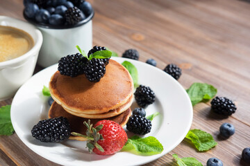 Pancakes for breakfast with blackberries and strawberries. Fluffy and delicious buttermilk pancakes.