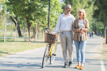 Elderly couple lifestyle concept. Husband and wife and sit walking in the park.