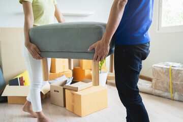 Asian couple moving heavy furniture to new home.