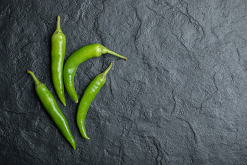 Top view of green hot peppers on black background