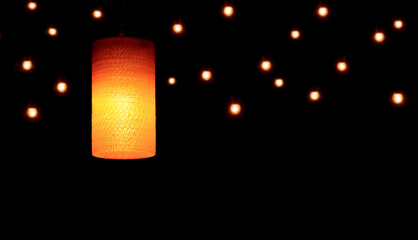 Vintage glass ceiling lamp with blurred hanging decorative lights in night background