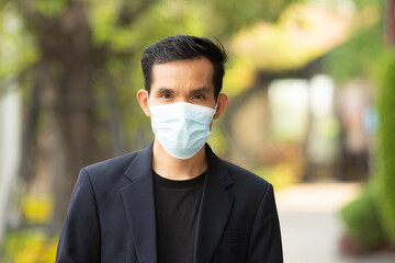 Asian man wear medical mask protect coronavirus covid 19 walking on street urban lifestyle new normal