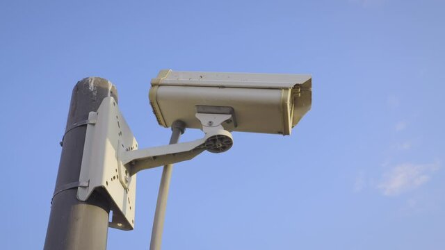Security camera cctv video surveillance mounted on extremity steel pole and clear blue sky background, Old cctv cameras on to the top pillar on sunny day, Electronic camera monitor record,
handheld. 