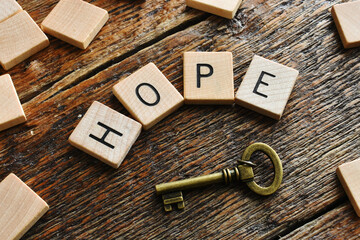 An inspirational message and vintage metal key on a dark wooden background.