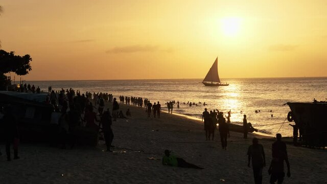 Silhouette of Sailing Boat Dhow Sails at Sunset on the Shore Beach, Zanzibar