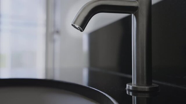 Close up wash basin water drop in bathroom, Stainless steel water tap or water vale have water drop,Slow motion water drop chrome faucet in the toilet,Concept save water energy and protect environment