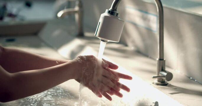 A person washing the hands in a water bath