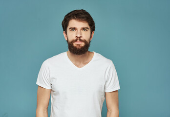 Obraz premium man in a white t-shirt on a blue background fast beard mustache Model