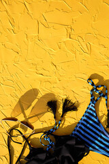 Blue with black stripes female swimsuit and sunglasses on a yellow background. The concept of a beach holiday, a trip to the sea, accessories for swimming, UV protection, tanning. Copyspace. Flatlay