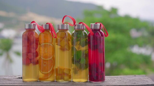 A set of colorful glass bottles with different flavors of kombucha drink, such as watermelon, orange, mango, mint, dragon fruit. Healthy and natural drinks
