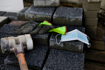 Coronavirus COVID-19 protective mask placed on a concrete paving stone
