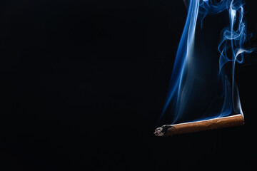 Cigarette with smoke on dark background