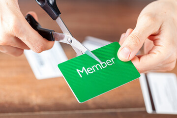 Close up isolated image of A young woman cutting a membership card. Customizable with copy space on the card. Suitable for cutting the costs, cancellation, termination of subscription and membership