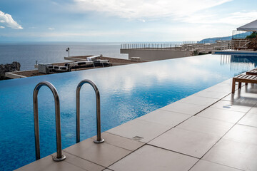 The side of the pool with stairs and tiles. The holiday season is a holiday destination, concept Wallpaper, background, picture without people with empty copy space for your text.