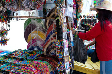 Fototapeta na wymiar Muchacha con cubrebocas en mercado de artesanías. Artesanías mexicanas.