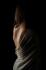 Obraz premium Back view of a beautiful half naked woman. Vertical shot, isolated black background.