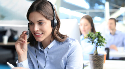 Portrait of call center worker accompanied by his team. Smiling customer support operator at work.