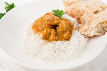Chicken with rice in curry sauce-a traditional Indian dish on a white background