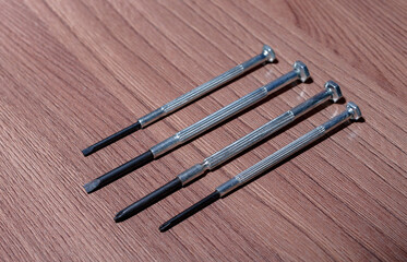 A set of magnetic screwdrivers for twisting and unscrewing screws and self-tapping screws on a wooden close-up