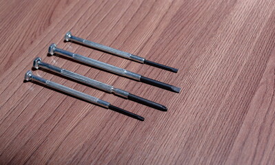 A set of magnetic screwdrivers for twisting and unscrewing screws and self-tapping screws on a wooden close-up