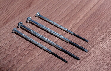 A set of magnetic screwdrivers for twisting and unscrewing screws and self-tapping screws on a wooden close-up