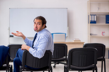 Young male business trainer in the office during pandemic