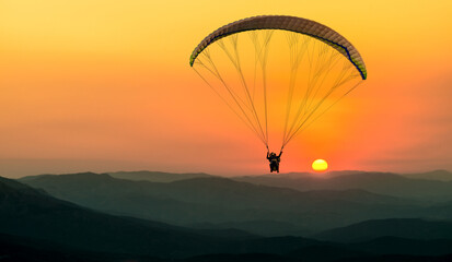 Naklejka na ściany i meble paraglider pilot fly in sky on beauty nature mountain landscape