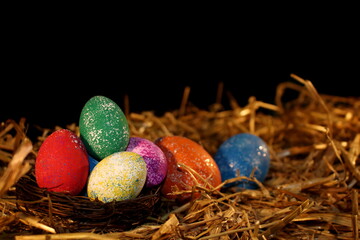 beautiful colorful Easter eggs lie on the straw