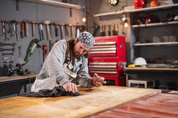 Male carpenter working on old wood in a retro vintage workshop.