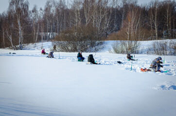 Fishermen on a frozen river. Winter fishing.