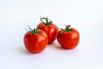Three red tomatoes isolated on a white background