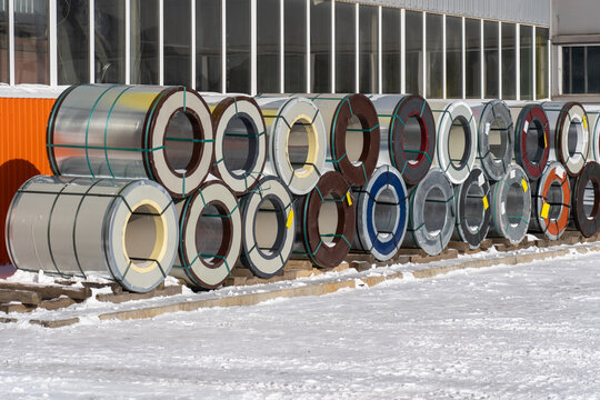 Rolls of sheet metal are stored on a skuld in the open air in winter