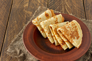 Crepes or Russian Blini on wooden backgroundin rustic style. Homemade thin crepes for breakfast or dessert.