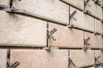 Installation of tiles with crosses on the wall.