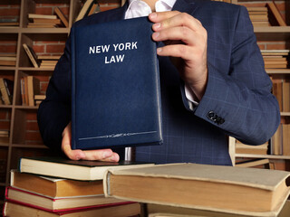 Attorney holds NEW YORK LAW book. New York residents are subject to New York state and U.S. federal...