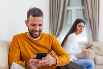 Jealous suspicious mad wife arguing with obsessed husband holding phone texting cheating on cellphone, distrustful girlfriend annoyed with boyfriend mobile addiction, distrust social media dependence